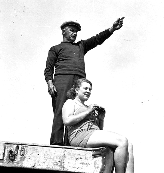 29th August 1936:  Standing on the beach at Dover, trainer Charles Cole points in the direction of France to US swimmer Eva Morrison, who plans to swim the English Channel.  