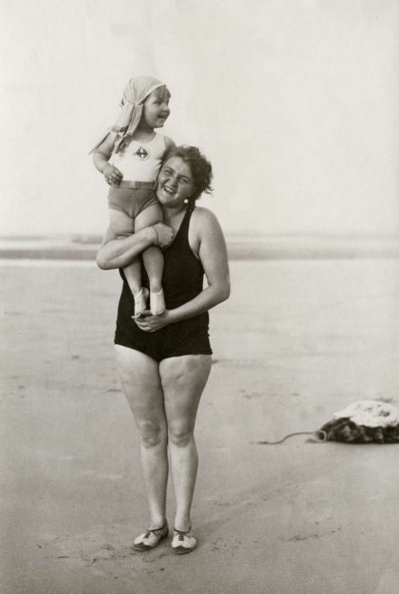 Mrs. Brouwer before her start to swim the Channel, with her child on her arm on the beach. France, at Gris Nez, 1930