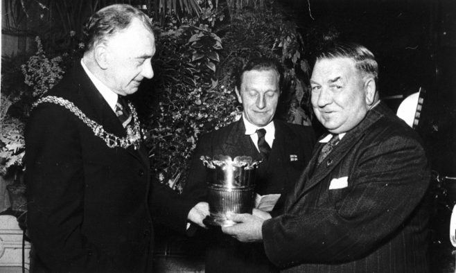 Jack Burvill receiving a trophy from Mayor Snelgrove (fishing?)
